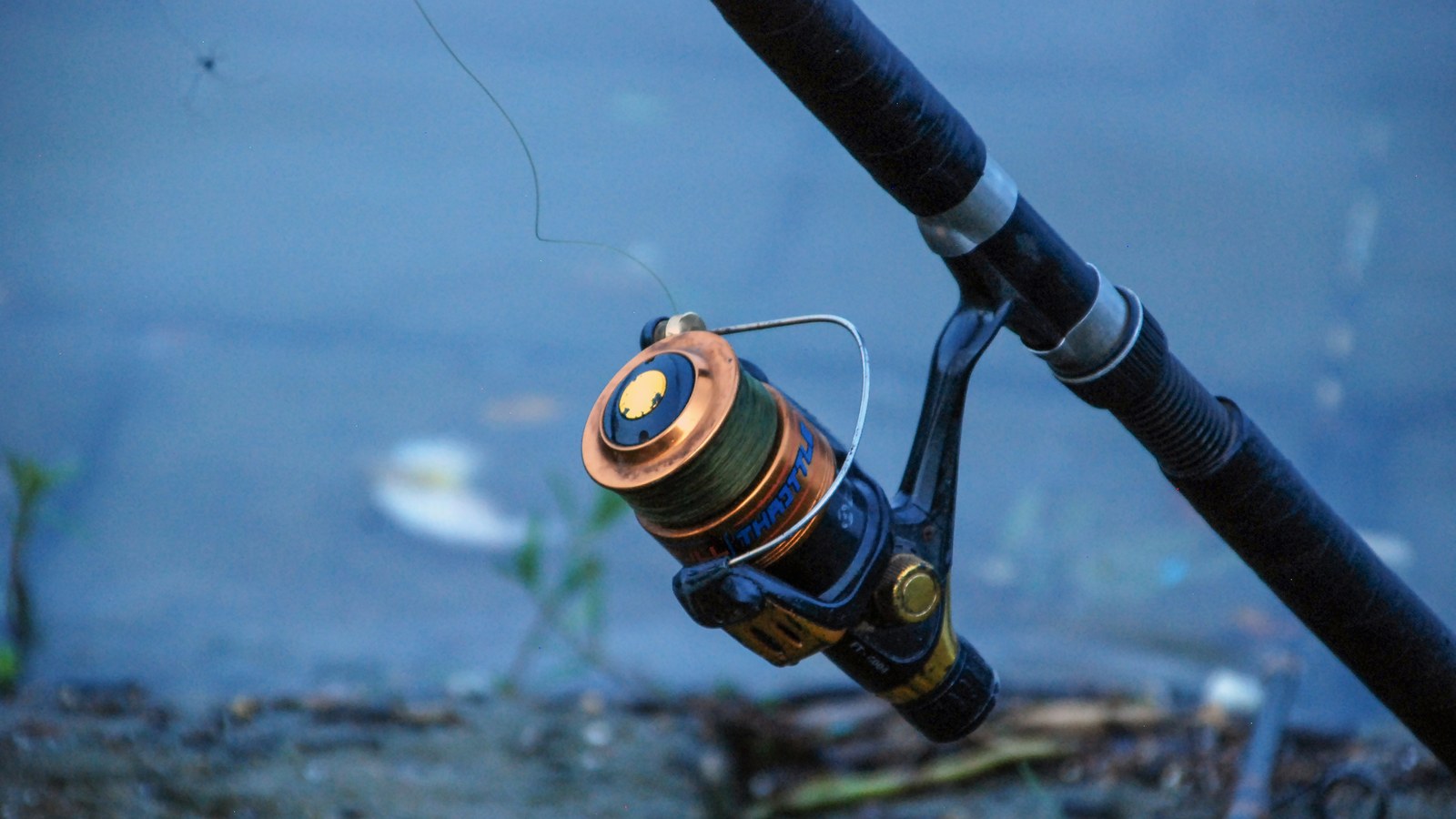 A fully rigged fishing kayak resting on a sandy riverbank at dawn, ready for an Australian angling trip.