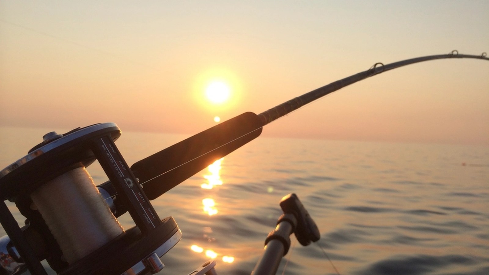 A digital fishing scale and measuring mat laid out on a wooden dock for accurate catch recording.