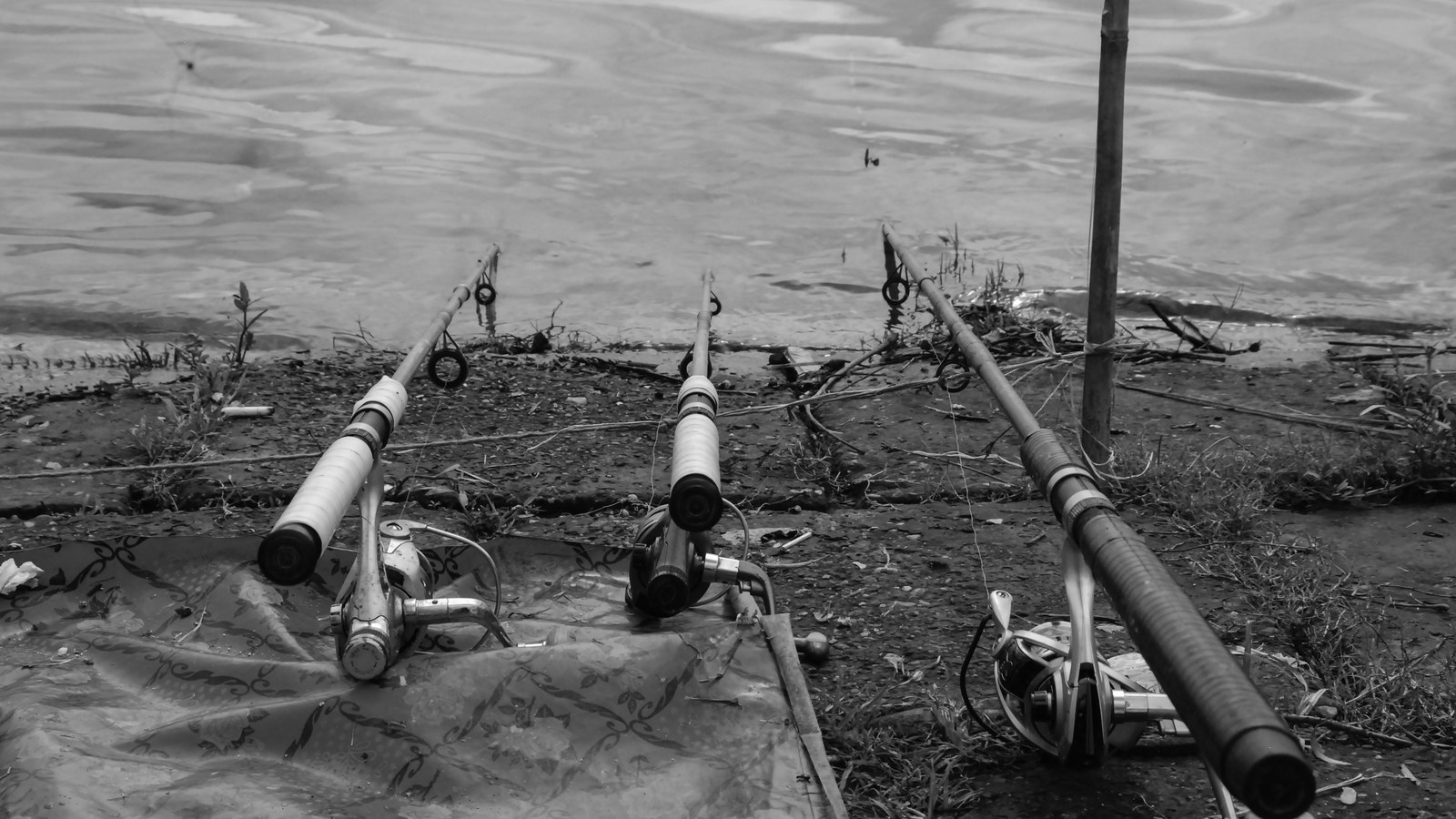 A bright kayak fishing life jacket resting on a kayak bow near calm water.