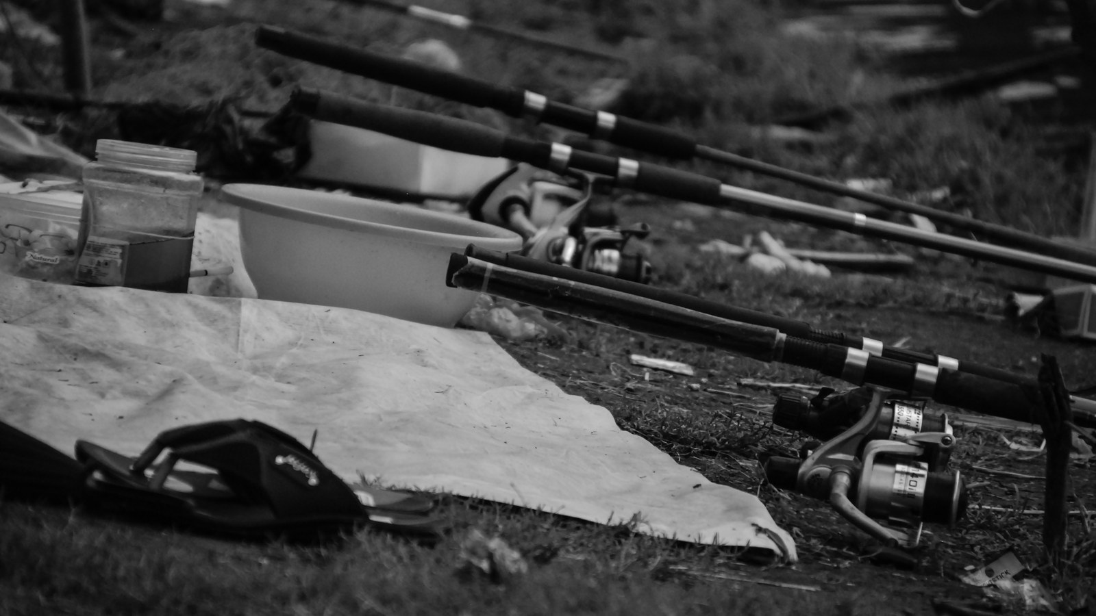 A bright yellow waterproof dry bag sitting on a wet boat deck next to fishing gear.