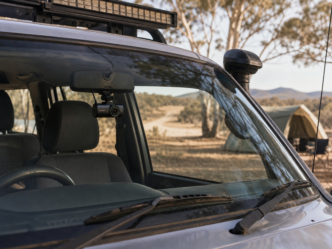 Dash cam mounted inside a 4x4 touring vehicle at a campsite