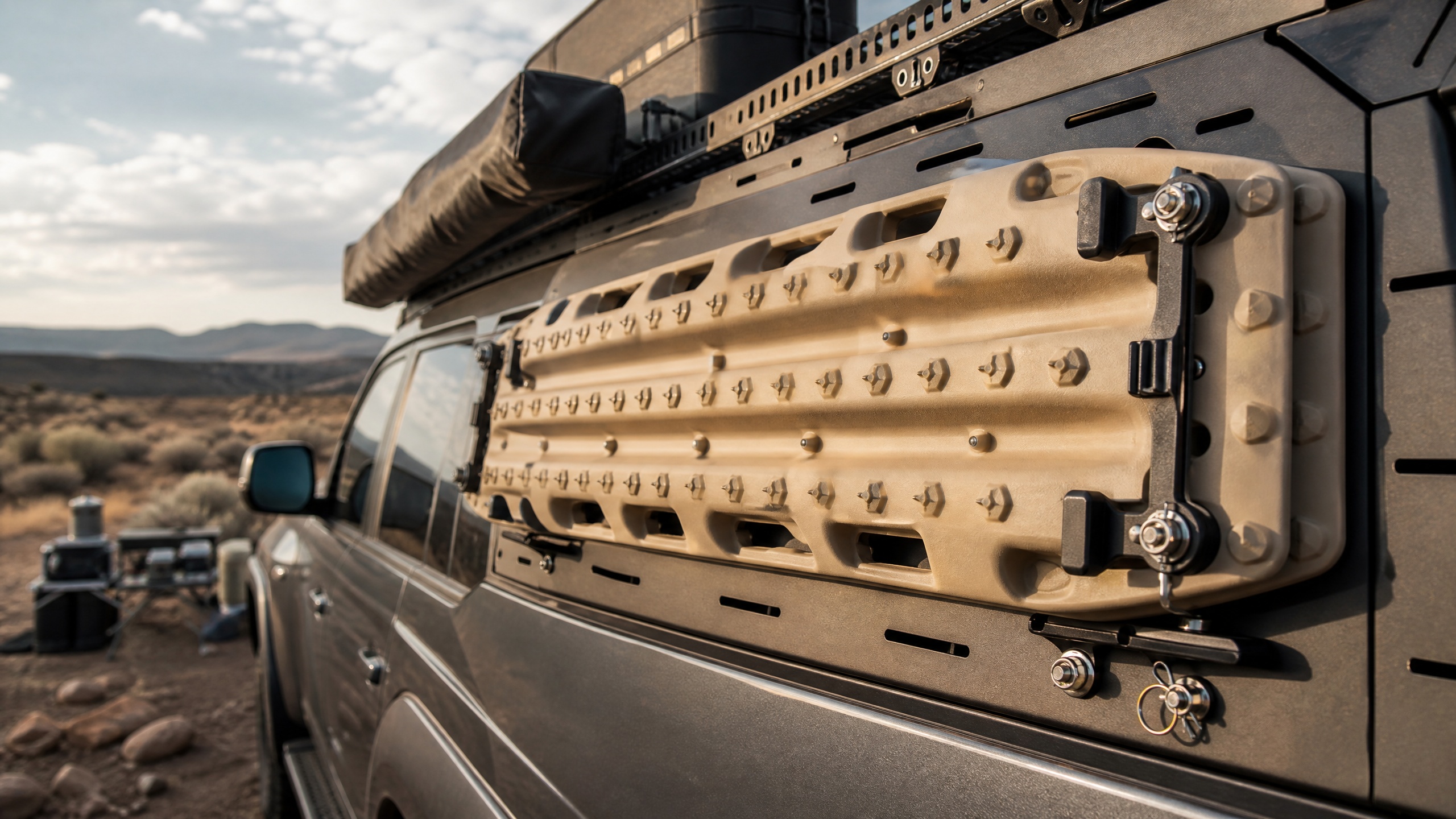 Sand-coloured recovery tracks secured to a 4x4 roof platform with mounting brackets