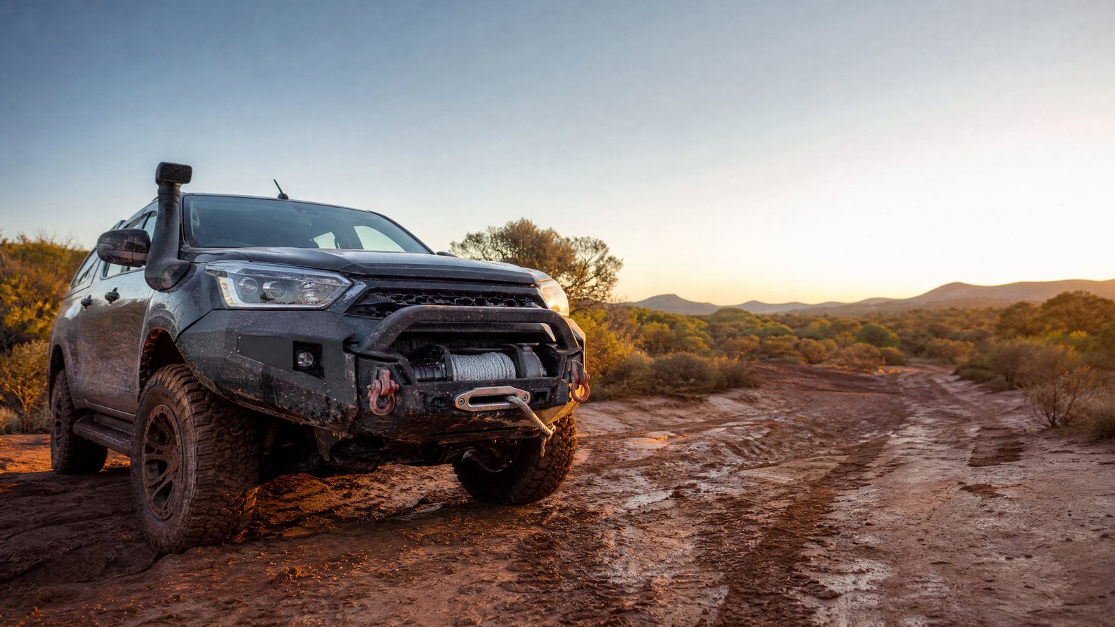 4x4 vehicle with front winch on muddy off-road track