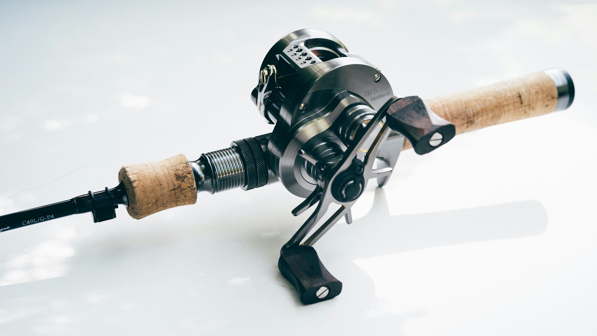 Close-up of a baitcasting reel mounted on a rod.