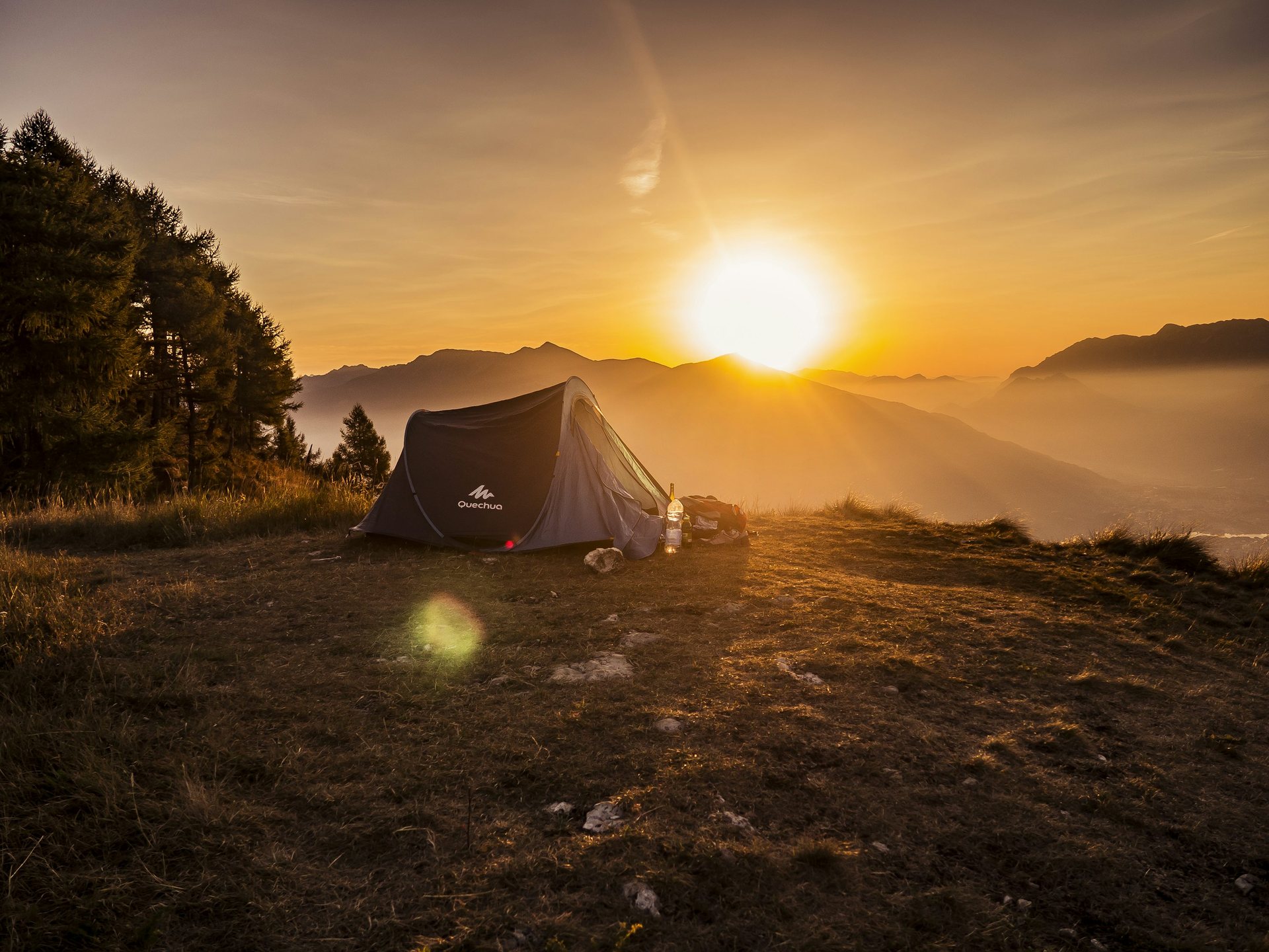 Large camping tent set up at a mountain campsite at sunset