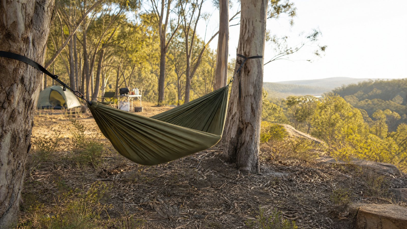 Camping hammock hung with wide tree-friendly straps at a quiet bush campsite.
