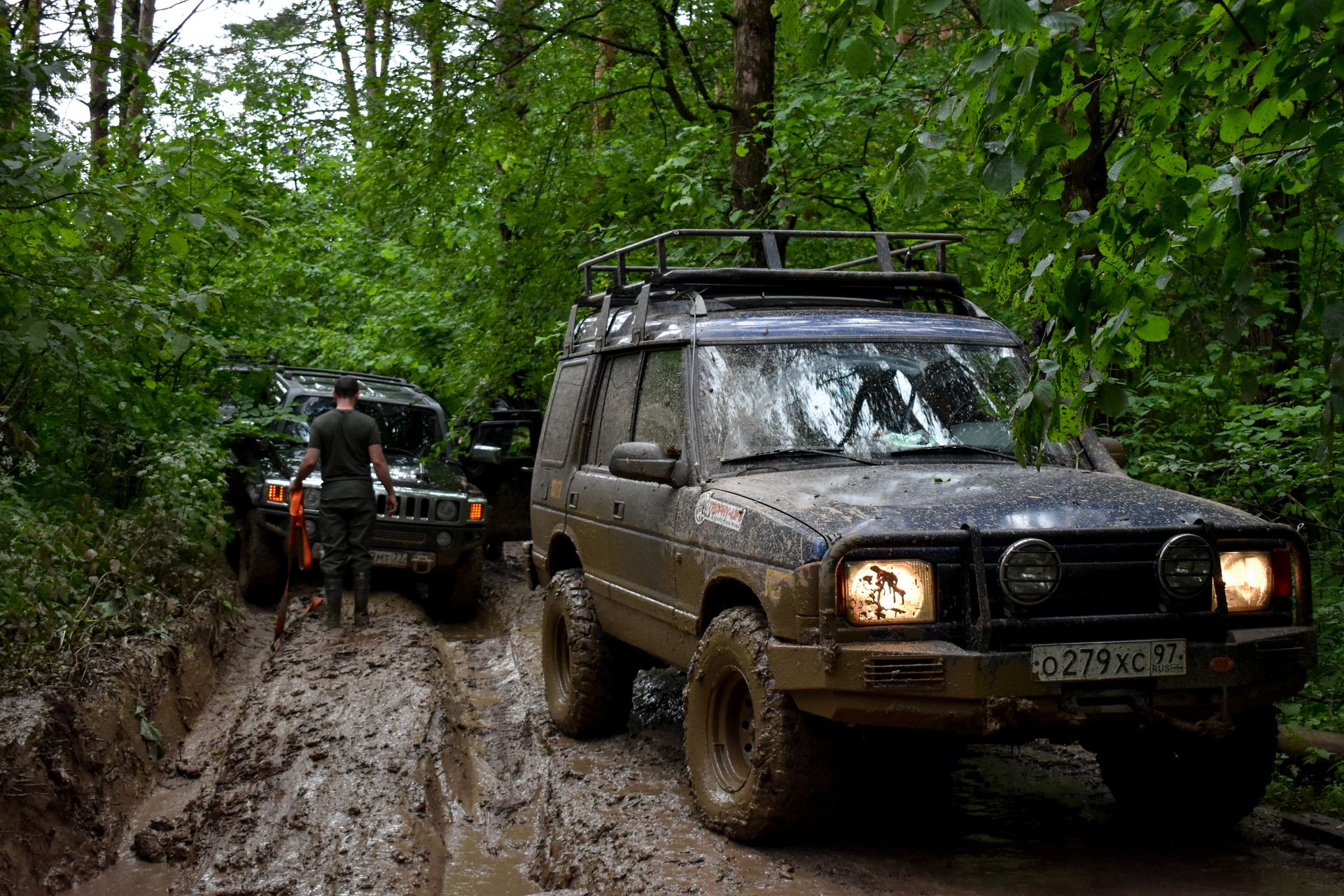 Four wheel drive on a muddy off-road track with its headlights on