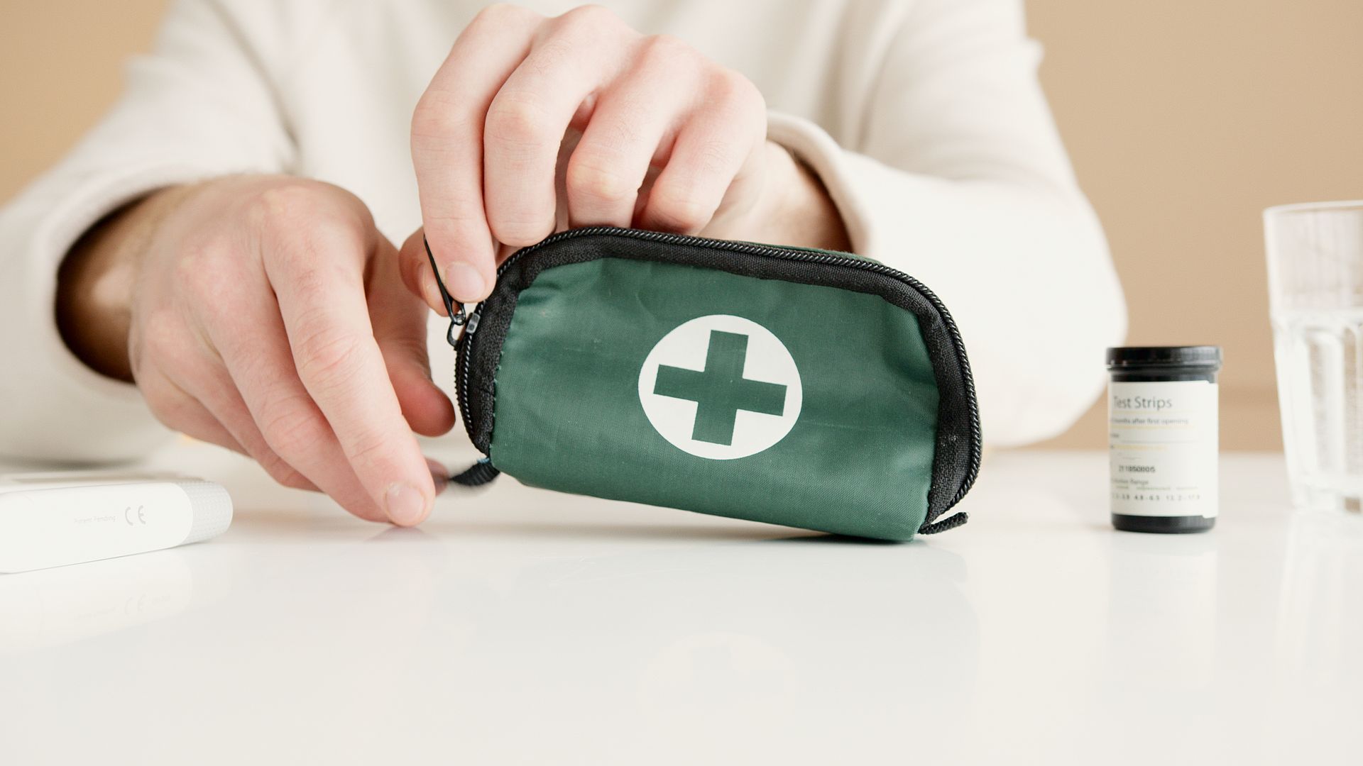 Hands opening a compact first aid kit pouch