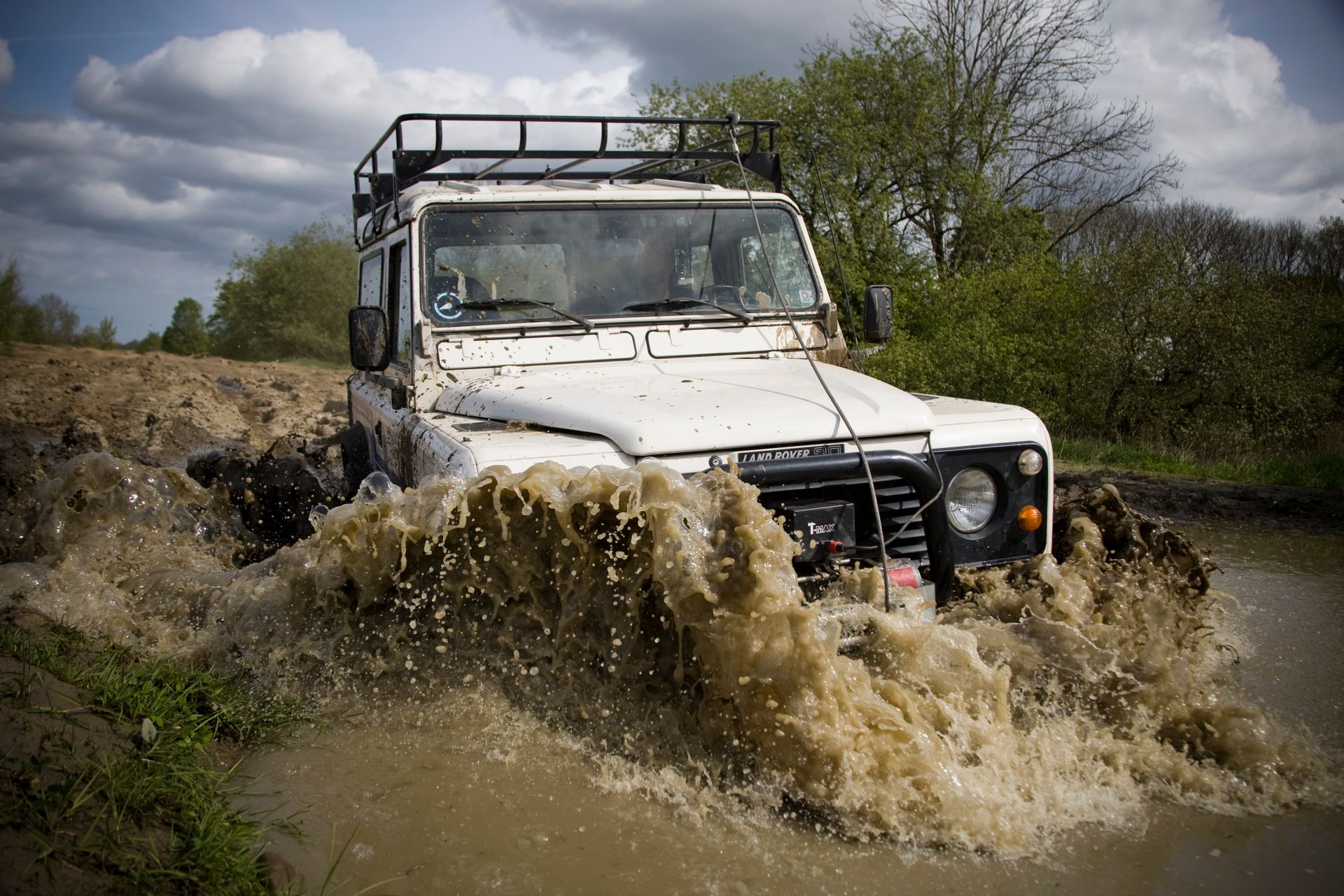 Four wheel drive vehicle driving through deep mud