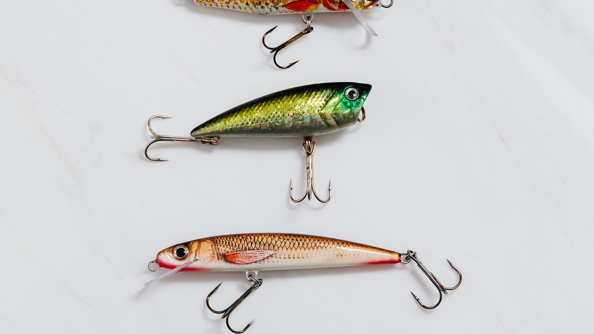 Flat lay of assorted bright fishing lures on a light background